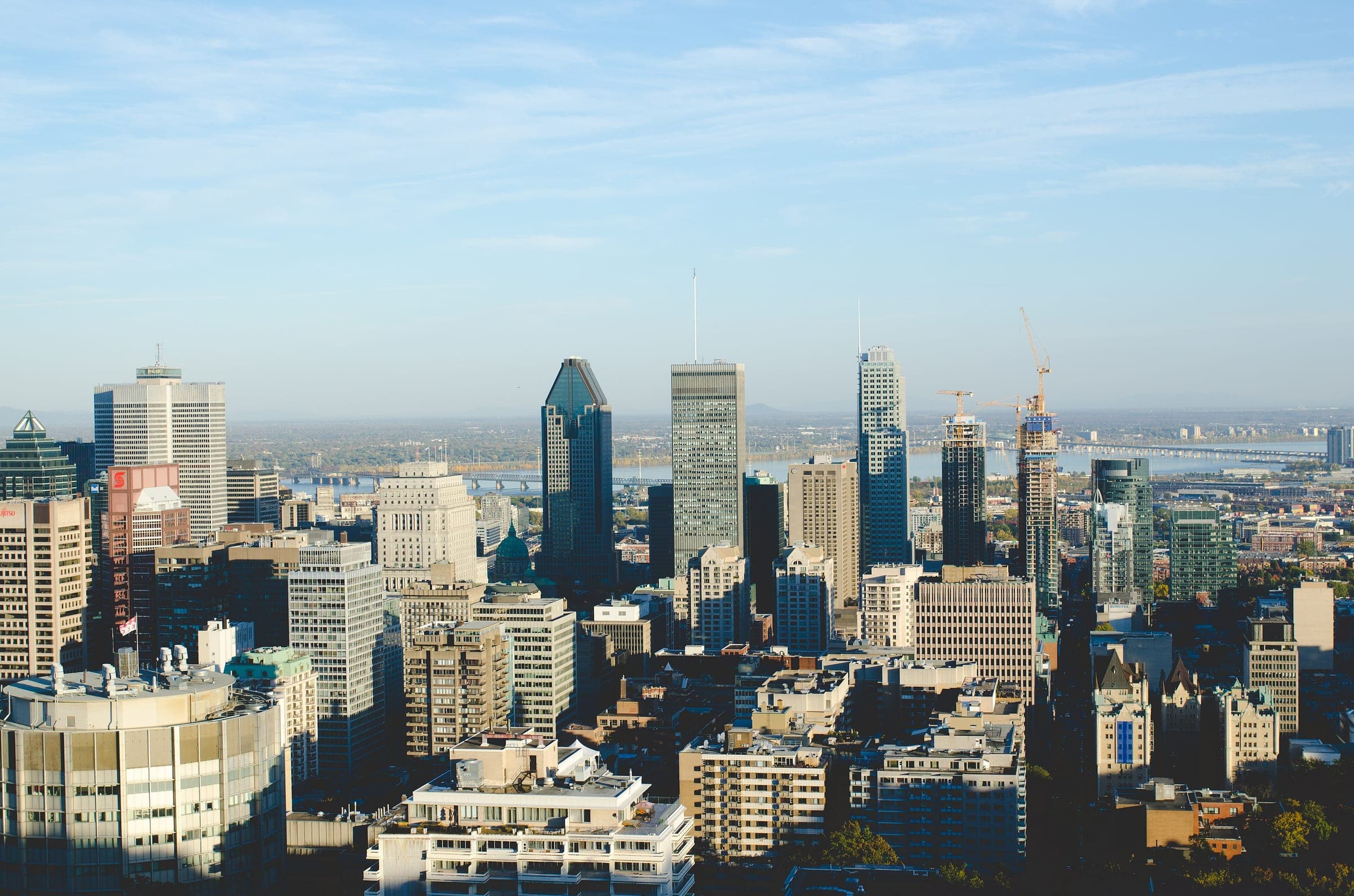 The downtown Montreal skyline seen from Mount Royal on a clear day, the St Lawrence beyond it